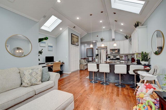living area with high vaulted ceiling, a skylight, baseboards, light wood-style floors, and ornamental molding