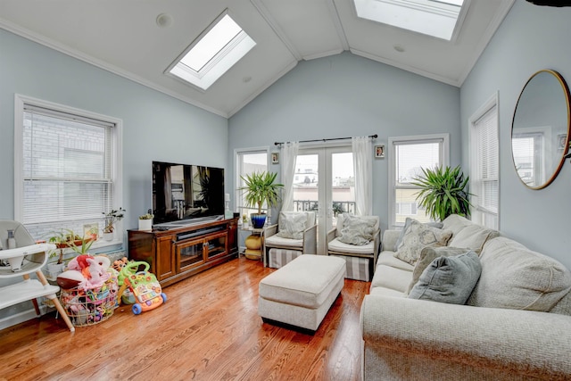 living room featuring high vaulted ceiling, a skylight, and light wood-type flooring
