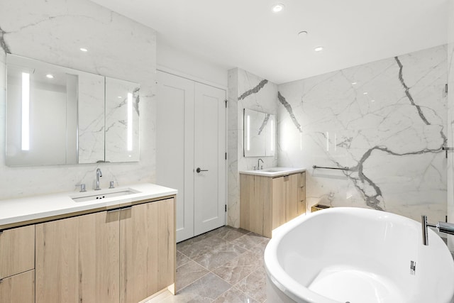 bathroom featuring a bathtub, vanity, and tile walls