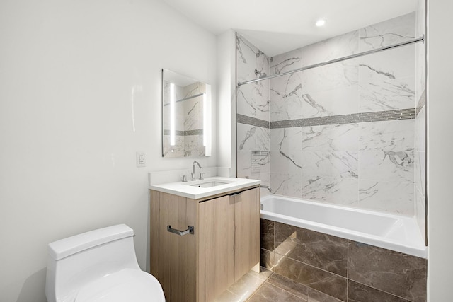 full bathroom featuring vanity, tiled shower / bath combo, and toilet