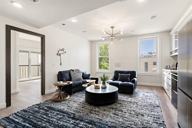 living room featuring a chandelier and light hardwood / wood-style flooring