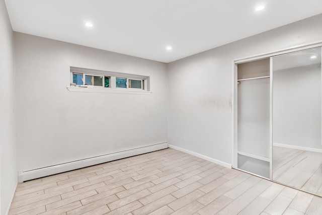 2200 Paterson Plank Rd Unit 23, North Bergen, NJ 07047 - unfurnished bedroom with a baseboard radiator, wood finished floors, recessed lighting, a closet, and baseboards