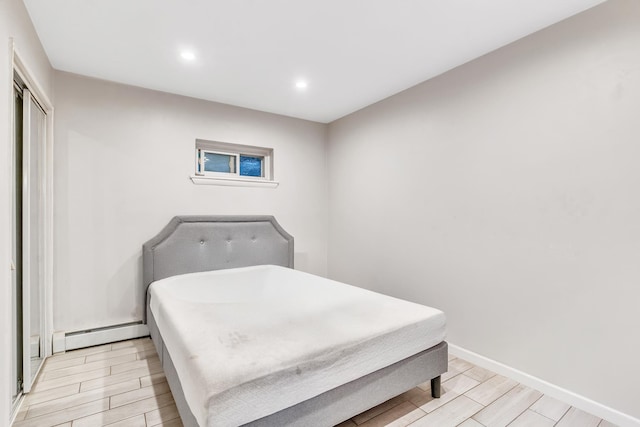 2200 Paterson Plank Rd Unit 23, North Bergen, NJ 07047 - bedroom featuring wood tiled floors, recessed lighting, baseboards, a closet, and baseboard heating