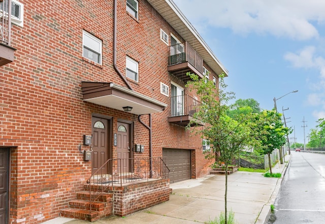 2200 Paterson Plank Rd Unit 23, North Bergen, NJ 07047 - entrance to property with concrete driveway, a balcony, brick siding, and a garage