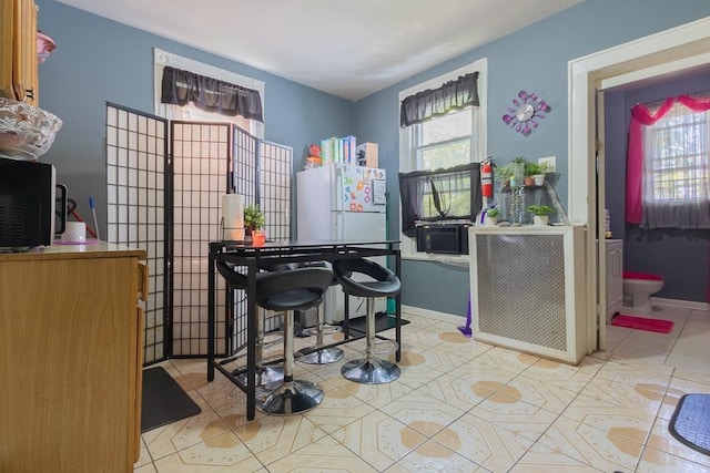 interior space with plenty of natural light, white fridge, and light tile patterned floors