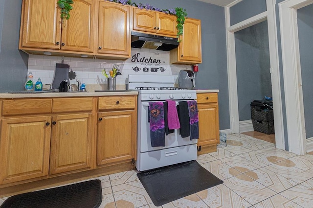 kitchen with white gas stove, backsplash, and light tile patterned floors