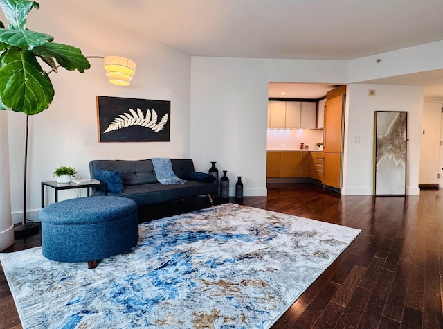 living room featuring dark wood-type flooring and baseboards