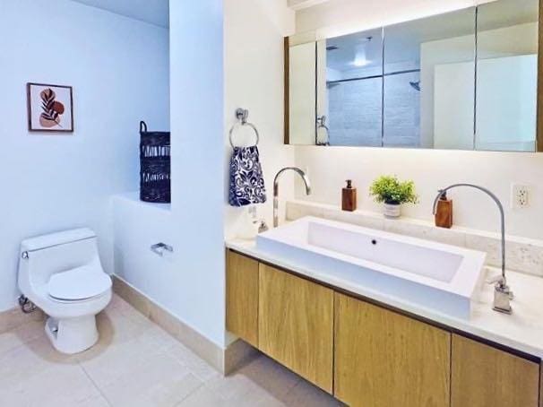 full bath featuring toilet, vanity, and tile patterned flooring