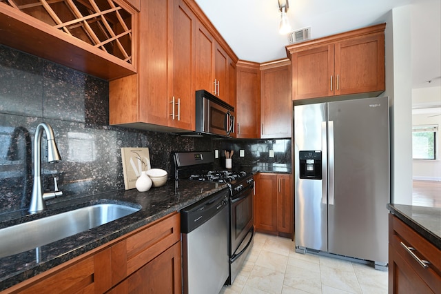 136 41st St Unit 103, Union City, NJ 07087 - kitchen with stainless steel appliances, a sink, brown cabinetry, and tasteful backsplash