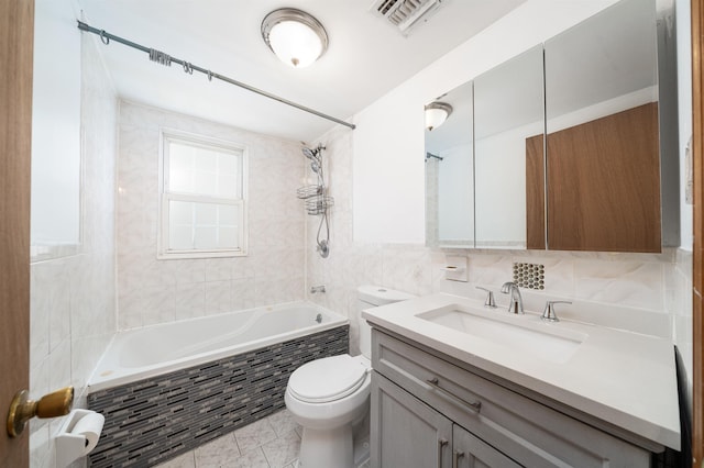 full bath with vanity, visible vents, tiled shower / bath combo, tile walls, and toilet