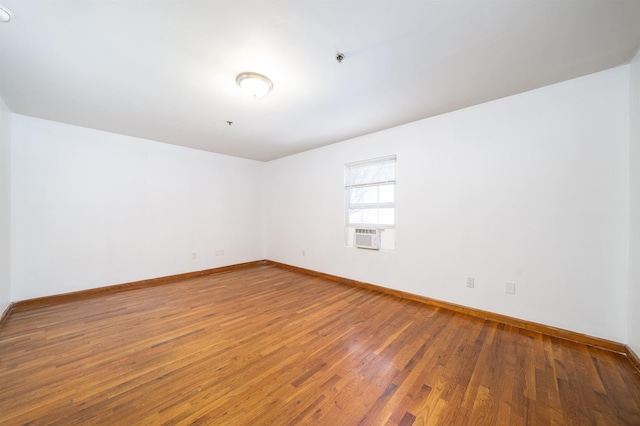 unfurnished room featuring baseboards and hardwood / wood-style flooring