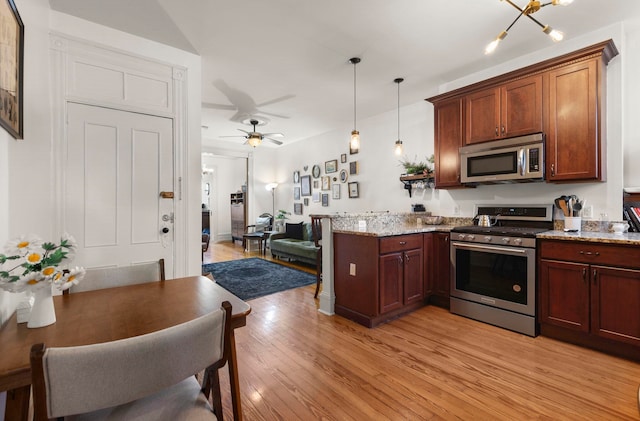 1114 Hudson St Unit 9, Hoboken, NJ 07030 - kitchen featuring appliances with stainless steel finishes, light wood-style floors, a peninsula, pendant lighting, and a ceiling fan