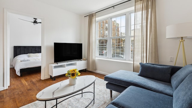 living room featuring ceiling fan and dark hardwood / wood-style flooring