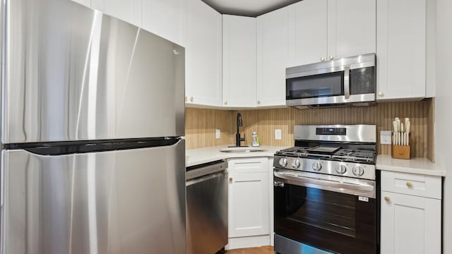 kitchen featuring sink, appliances with stainless steel finishes, and white cabinetry