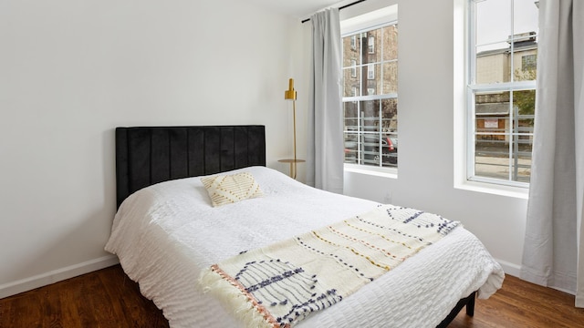 bedroom with dark hardwood / wood-style flooring and multiple windows