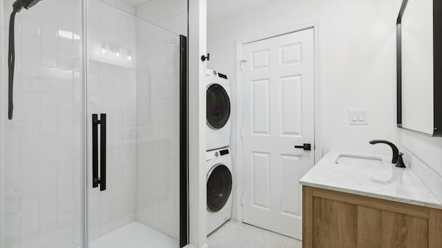 washroom with stacked washer and clothes dryer and sink