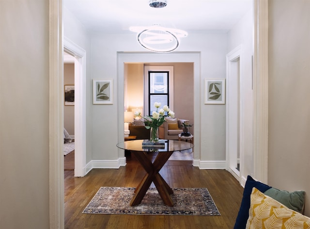 hallway featuring an inviting chandelier and dark hardwood / wood-style floors