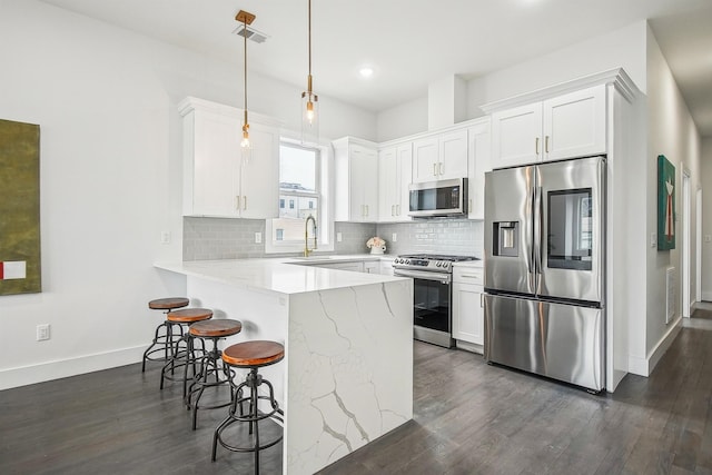 98 Van Horne St Unit A, Jersey City, NJ 07304 - kitchen with white cabinets, a peninsula, a kitchen breakfast bar, and stainless steel appliances