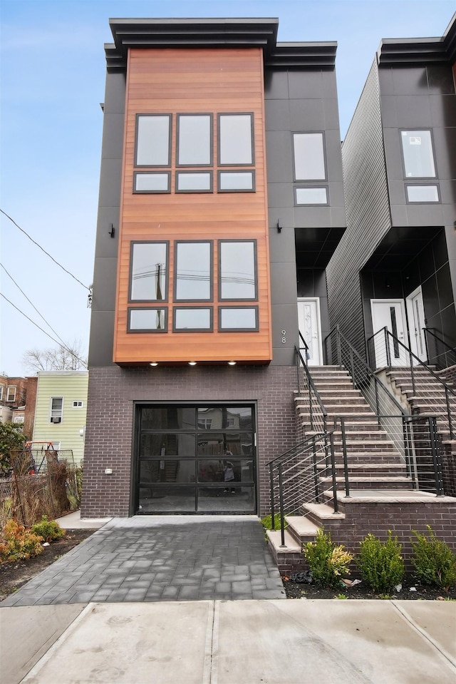 98 Van Horne St Unit A, Jersey City, NJ 07304 - modern home with driveway, an attached garage, and brick siding