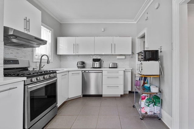 179 W 8th St, Bayonne, NJ 07002 - kitchen with appliances with stainless steel finishes, under cabinet range hood, light countertops, white cabinetry, and tasteful backsplash