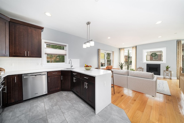 31 Ravine Ave Unit 1, Jersey City, NJ 07307 - kitchen with dishwasher, a sink, a peninsula, dark brown cabinetry, and light countertops