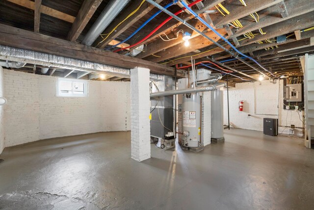 195 Stanley Pl, Hackensack, NJ 07601 - basement featuring water heater, brick wall, electric panel, and heating unit