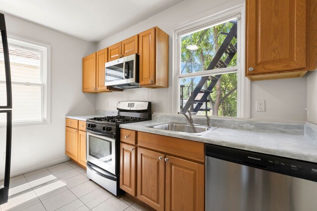 195 Stanley Pl, Hackensack, NJ 07601 - kitchen featuring appliances with stainless steel finishes, light countertops, light tile patterned floors, and brown cabinets