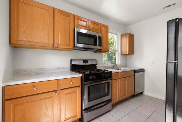 195 Stanley Pl, Hackensack, NJ 07601 - kitchen featuring stainless steel appliances, light countertops, light tile patterned floors, and brown cabinetry