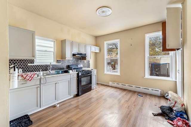 914 19th St, Union City, NJ 07087 - kitchen featuring baseboard heating, black range with gas cooktop, under cabinet range hood, light countertops, and light wood-type flooring