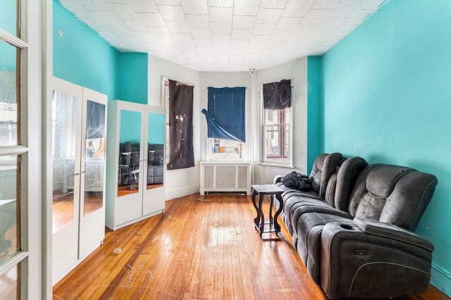 914 19th St, Union City, NJ 07087 - living area with radiator heating unit, wood-type flooring, and french doors