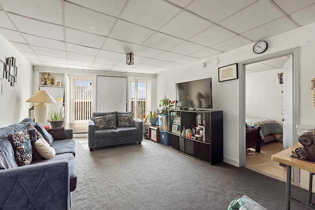carpeted living area with a drop ceiling