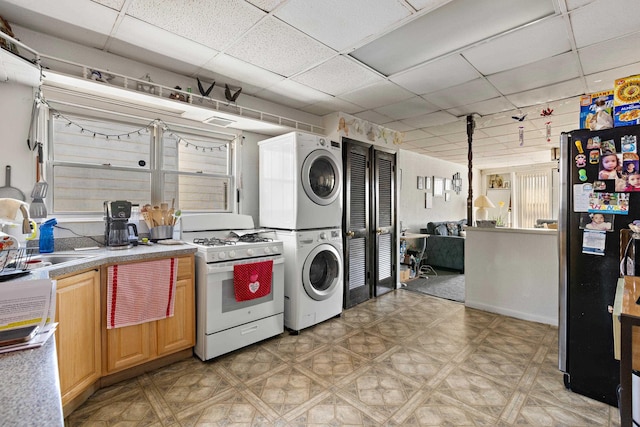 laundry room featuring stacked washer / dryer, laundry area, and light floors