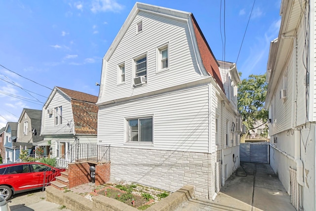 1224 80th St, North Bergen, NJ 07047 - view of property exterior with a gambrel roof, cooling unit, and stone siding