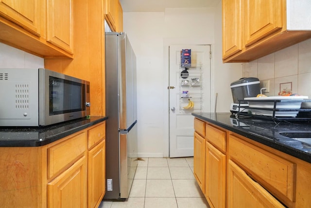 1224 80th St, North Bergen, NJ 07047 - kitchen featuring stainless steel appliances, light tile patterned floors, decorative backsplash, and dark stone countertops