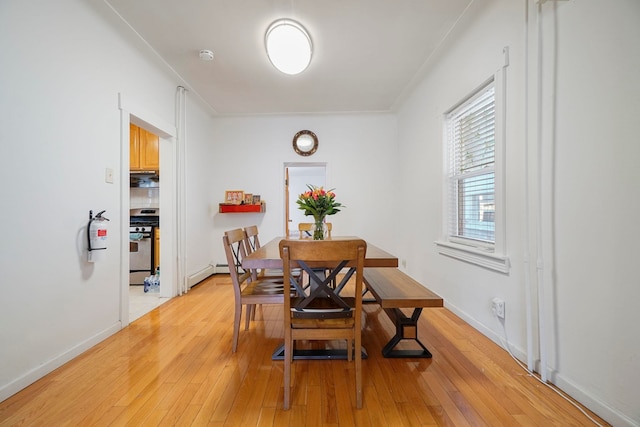 1224 80th St, North Bergen, NJ 07047 - dining area featuring light wood-style flooring, a baseboard heating unit, and ornamental molding