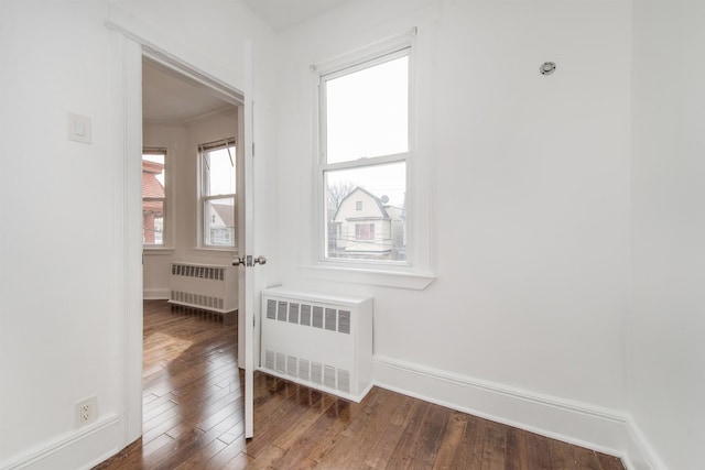 interior space featuring ornamental molding, dark hardwood / wood-style floors, and radiator heating unit