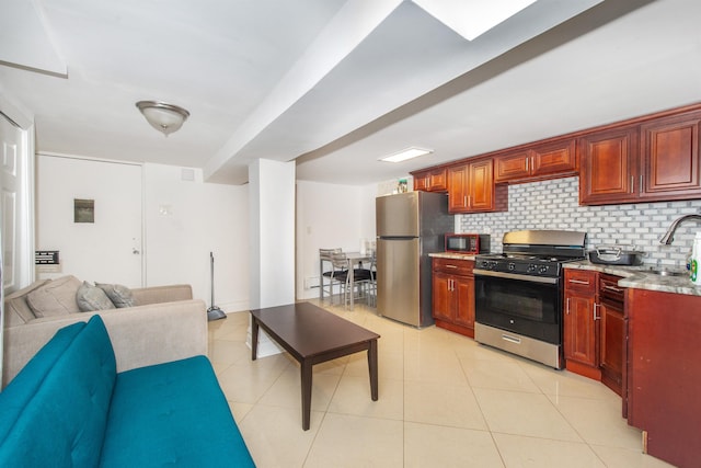 kitchen featuring backsplash, light tile patterned floors, stainless steel appliances, and sink