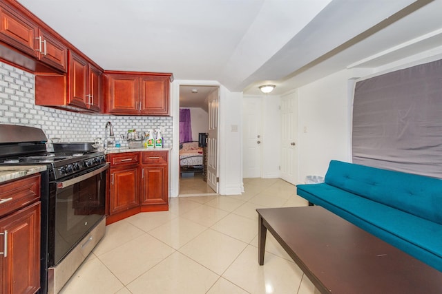 kitchen with light tile patterned floors, decorative backsplash, and stainless steel gas stove