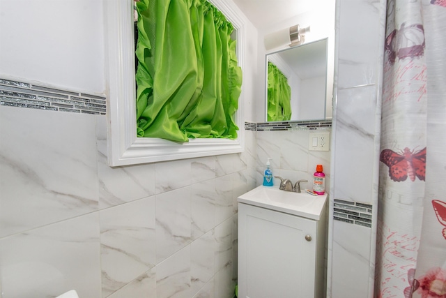 bathroom with vanity and tile walls