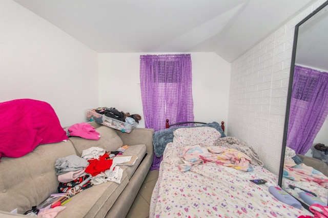 bedroom featuring lofted ceiling and tile patterned floors