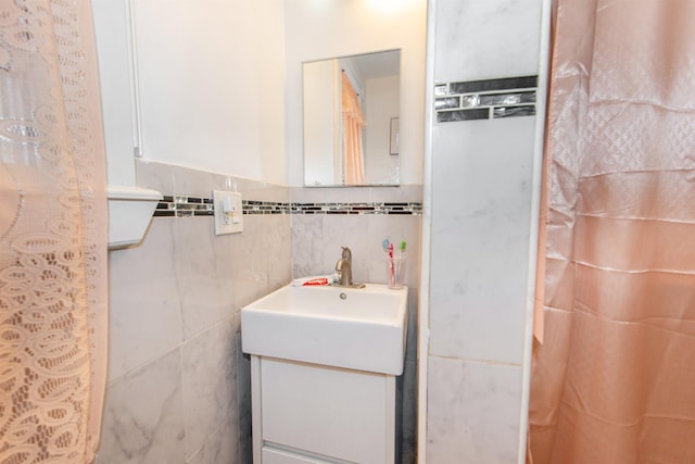 bathroom with vanity and tile walls