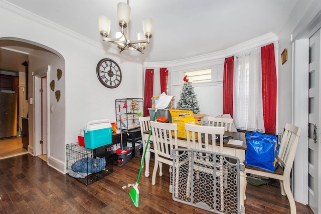 dining space featuring hardwood / wood-style flooring, ornamental molding, and a notable chandelier