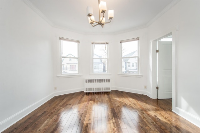 spare room featuring ornamental molding, radiator, an inviting chandelier, and dark hardwood / wood-style flooring