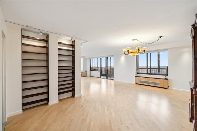 300 Winston Dr # 1822, Cliffside Park, NJ 07010 - unfurnished living room with a chandelier, track lighting, light wood-style floors, and radiator