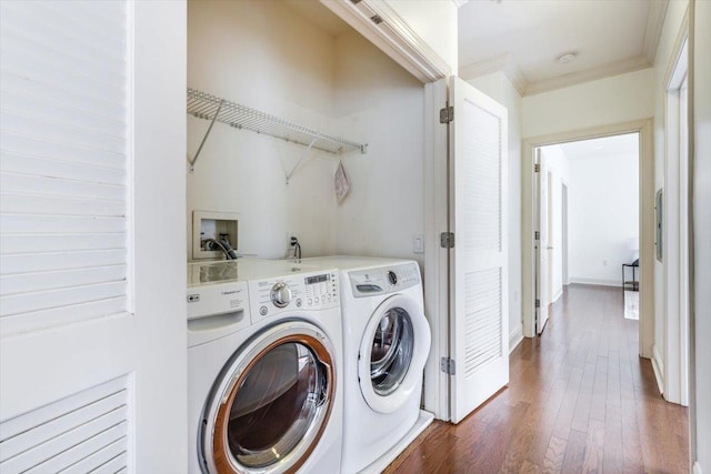 laundry room with laundry area, baseboards, dark wood-style floors, ornamental molding, and washing machine and clothes dryer