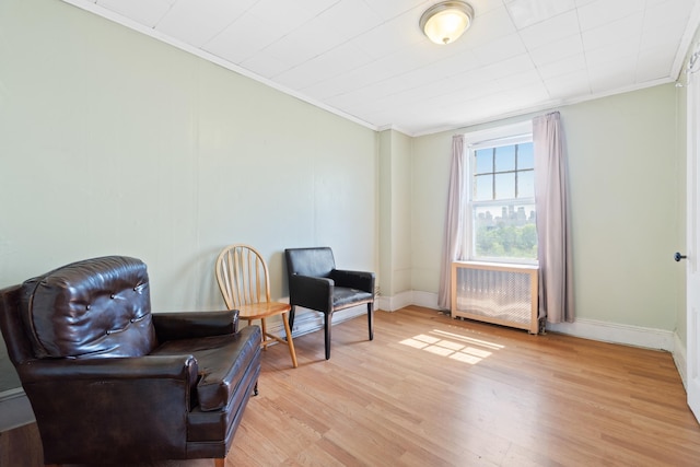 572 Gregory Ave, Weehawken, NJ 07086 - living area with radiator heating unit, ornamental molding, and light wood finished floors