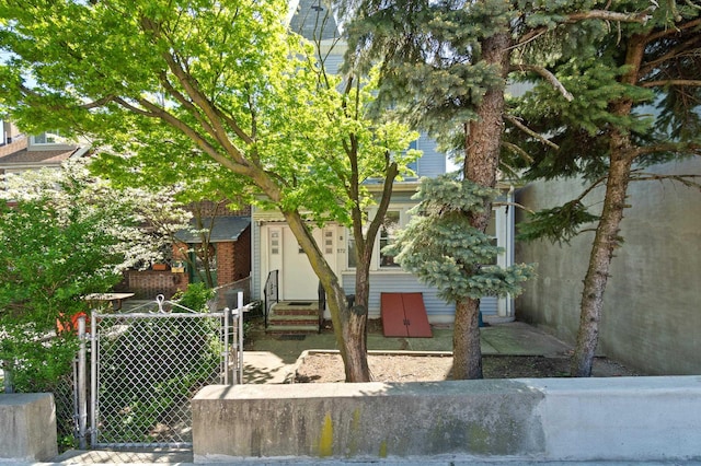 obstructed view of property featuring entry steps, fence, and a gate