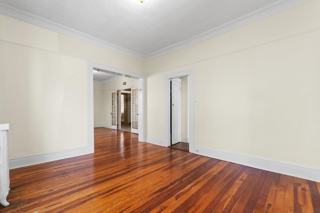 empty room with baseboards, ornamental molding, and wood-type flooring