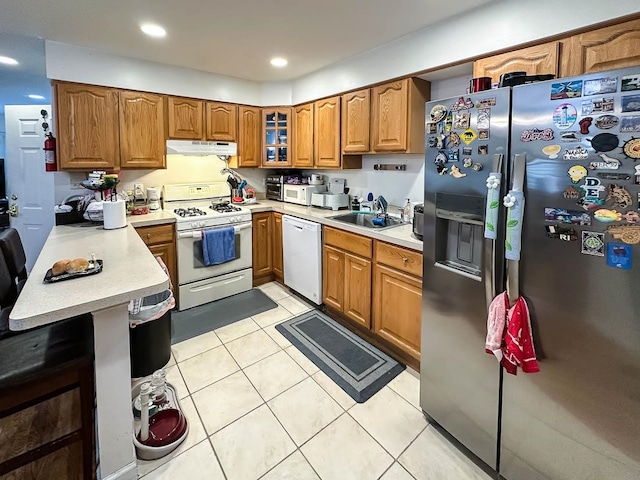 kitchen featuring white appliances, sink, and light tile patterned flooring