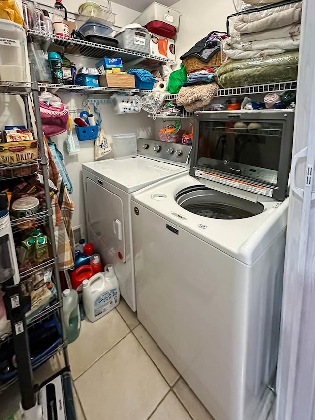 laundry room with washer and clothes dryer and tile patterned floors